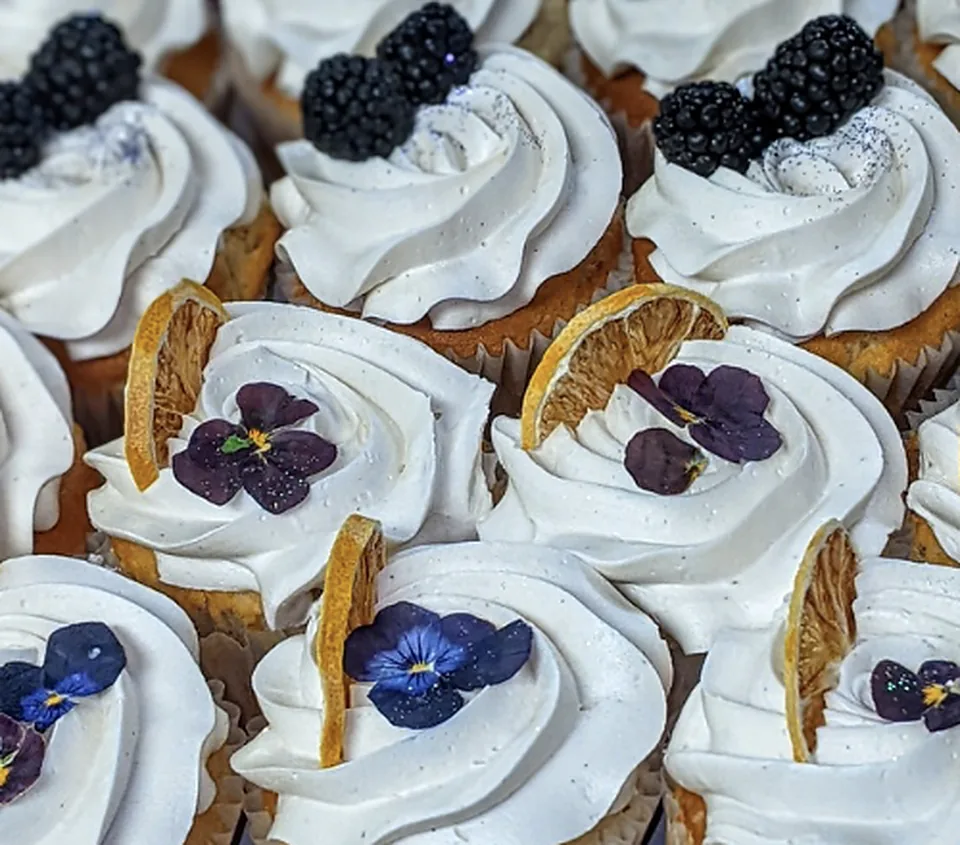 Cupcakes with blackberries, violas and dried orange