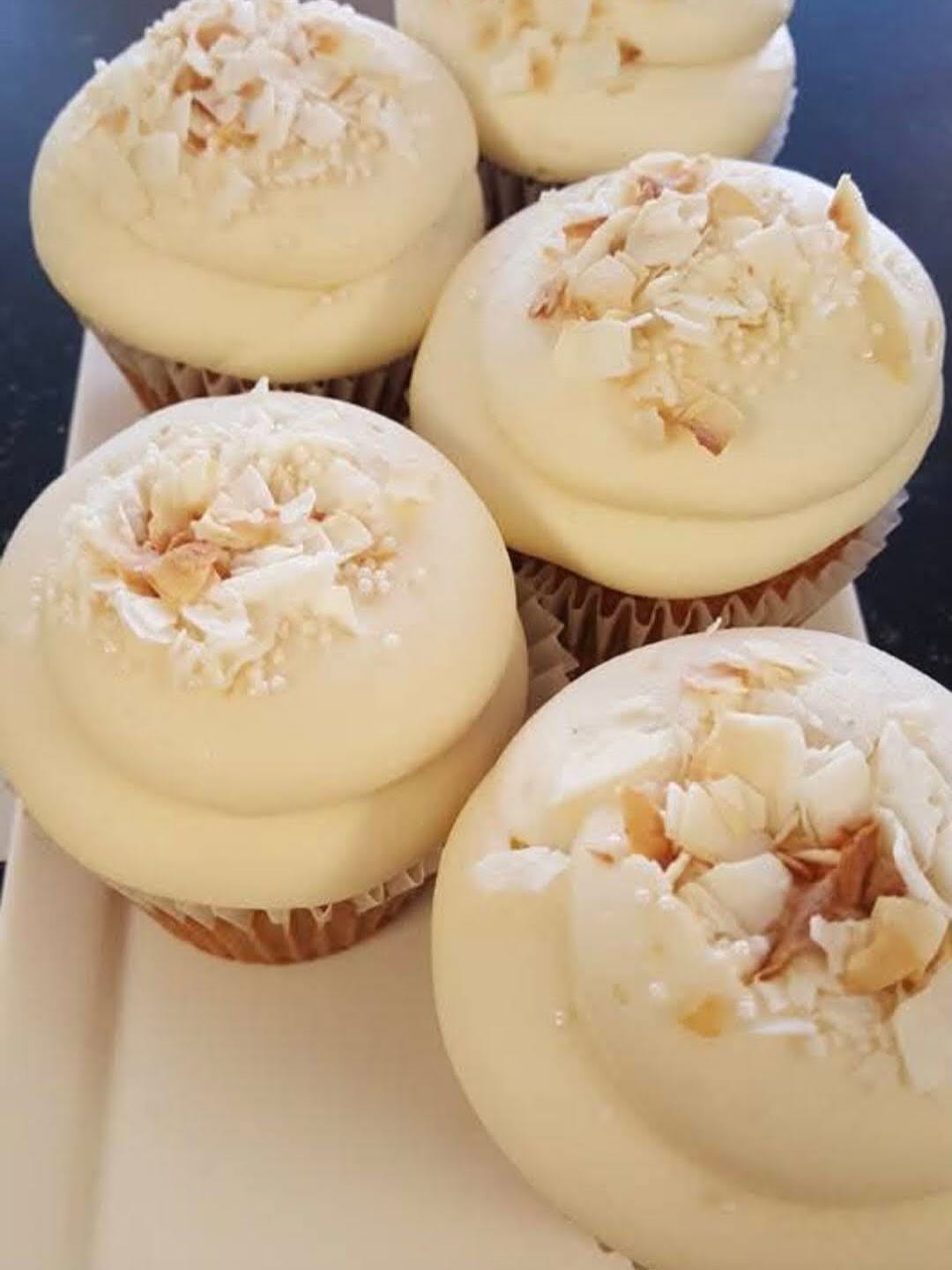 Cupcakes with pale frosting and toasted coconut flakes