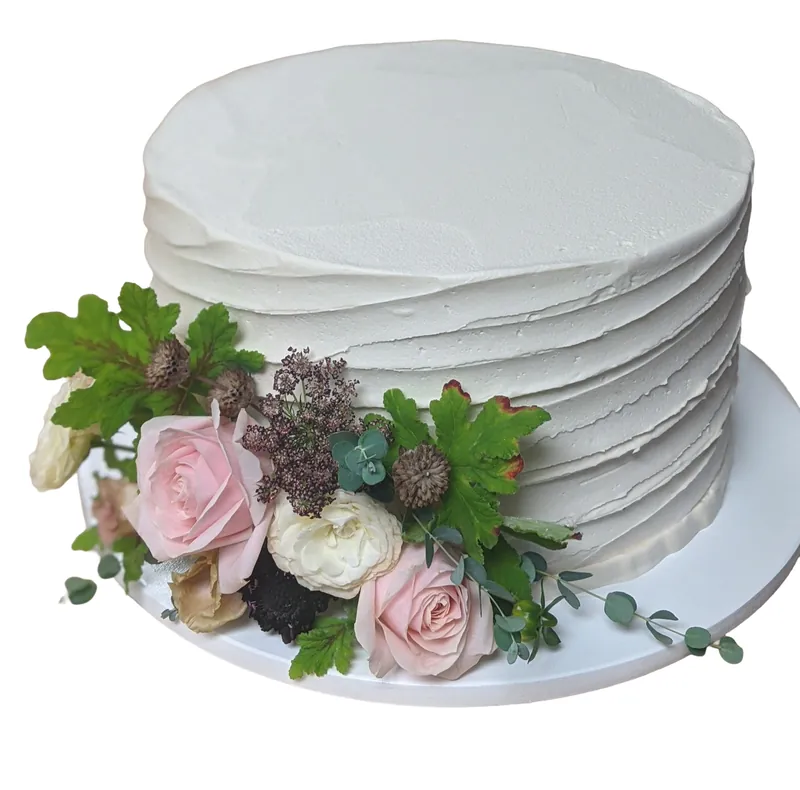 Celebration cake with pink roses, thistle and eucalyptus