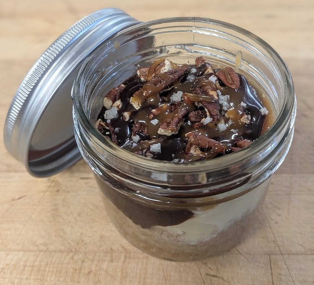Turtle cheesecake in a mason jar with ganache, salted caramel and pecans